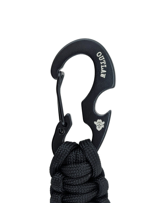 A black paracord keychain with a heavy-duty carabiner featuring the word 'OUTLAW' and a cowboy hat logo, set against a plain white background.